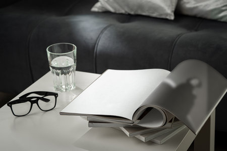 Eyeglasses with stack of books, and the glass of water on the tableの写真素材