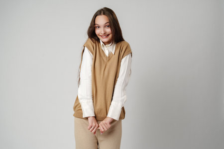 Photo of young shy adorable lady hold hands against gray background