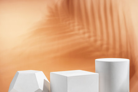 White geometric shapes arranged stylishly on a soft peach background in a minimalist settingの写真素材