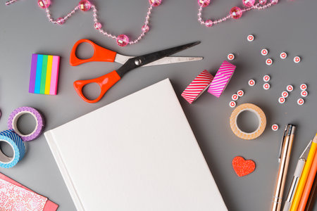 Crafting supplies arranged for a DIY project on a gray table with scissors, washi tape, and...