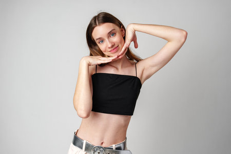 Smiling Young Woman Against White Background in Studioの写真素材