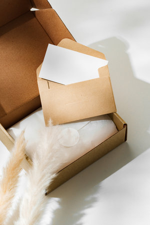 Delivery package with a blank envelope and decorative elements on a light background