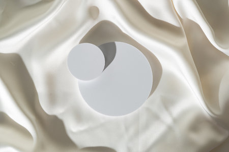 Modern Minimalist White Sculpture Displayed on Soft Draped Fabric in Natural Light