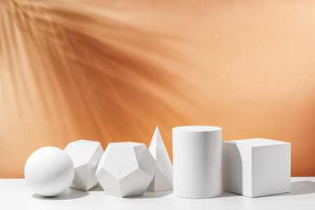 Various geometric shapes arranged artistically on a table with a warm, soft background during daylightの写真素材