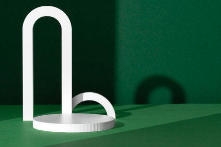 Modern White Architectural Shapes Against A Deep Green Background Displayed On A Simple Table Settingの写真素材