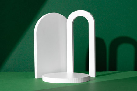 Modern White Architectural Shapes Against A Deep Green Background Displayed On A Simple Table Settingの写真素材