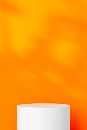 White cylindrical display on a bright orange backgroundの写真素材