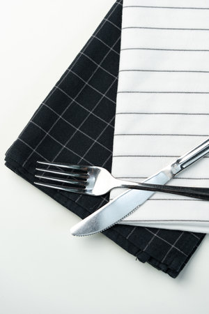 Cutlery placed on contrasting black and white napkins ready for dining at a table settingの写真素材