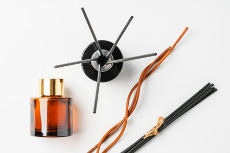 A minimalist display of essential oil and black diffuser sticks on a clean white backgroundの写真素材