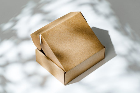 An open cardboard box rests on a bright white surface with soft shadowsの写真素材