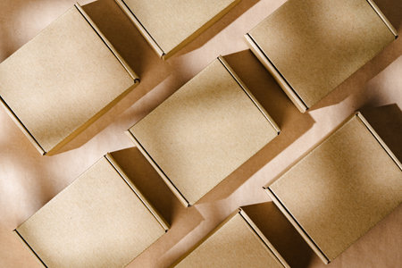 Brown cardboard boxes arranged neatly on a workspace, showcasing packaging materials for shipping and storage activitiesの写真素材