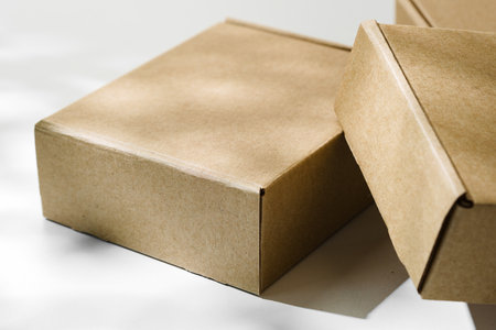 Three brown cardboard boxes arranged on a light surface with soft shadows