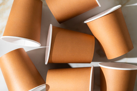Brown disposable cups scattered on a white surface during daylightの写真素材
