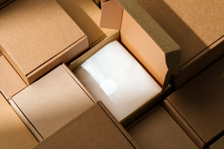 Stacked cardboard boxes arranged in a neat pattern under natural lightの写真素材