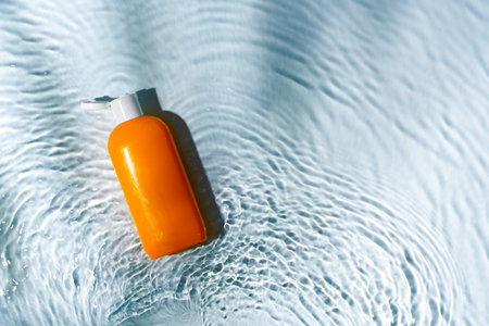 Skincare tube resting on textured surface illuminated by sunlightの写真素材