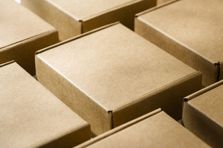 Brown cardboard boxes arranged on a neutral background in a warehouse setting during daylight hours