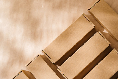 Brown cardboard boxes arranged on a neutral background in a warehouse setting during daylight hoursの写真素材