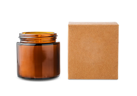 Amber glass jar with lid beside a brown kraft paper boxの写真素材