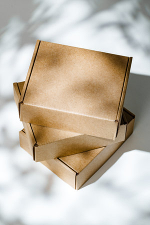 Freshly packed cardboard boxes resting on a white surface, illuminated by soft natural light