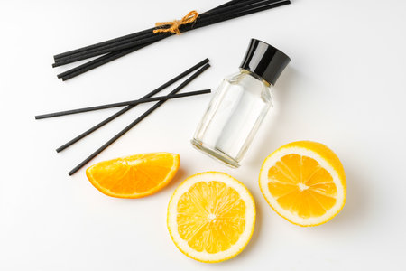 Aromatic display of essential oils with citrus fruit and chopsticks on a minimalist backgroundの写真素材