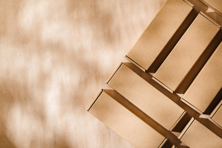 Brown cardboard boxes arranged on a neutral background during daylight hours