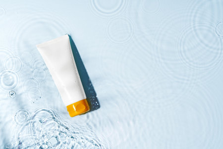 Colorful liquid soaps arranged on a smooth surface with ripples in warm sunlight