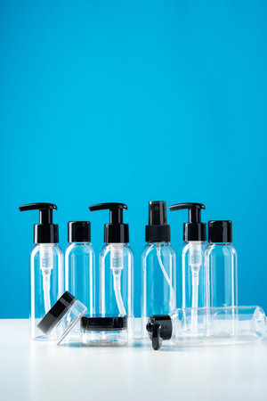 Plastic bottles with black caps are neatly arranged on blue background