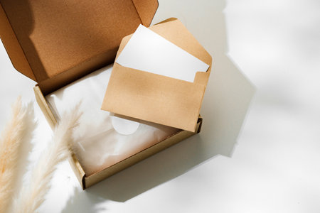 Delivery package with a blank envelope and decorative elements on a light background