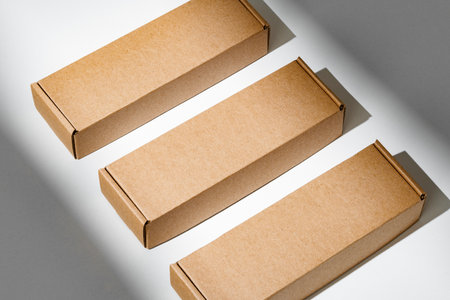 Freshly packed cardboard boxes resting on a white surface, illuminated by soft natural lightの写真素材