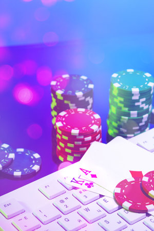 A vibrant arrangement of poker chips and playing cards on a gaming keyboard with a mouse at an...