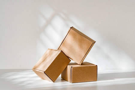 Freshly packed cardboard boxes resting on a white surface, illuminated by soft natural lightの写真素材