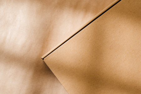 A plain cardboard box on a textured surface with soft light and shadows during the afternoonの写真素材
