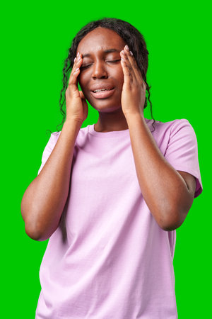 Woman expressing frustration while standing against a bright green backgroundの写真素材