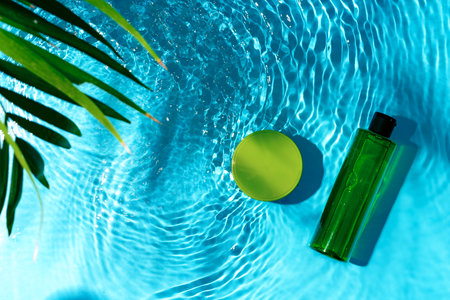 Green bottle floating on a clear blue swimming pool during bright daylight