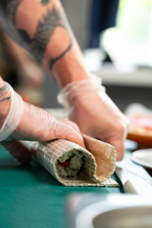 Preparing sushi rolls with fresh ingredients at a culinary studioの写真素材
