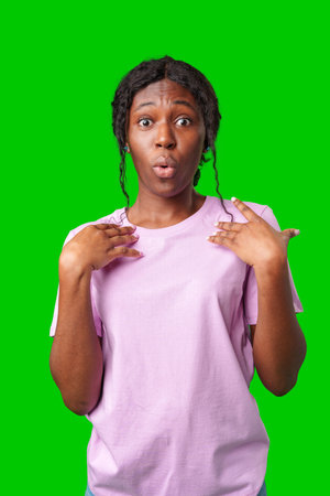 Woman expressing surprise and excitement on a bright green backgroundの写真素材