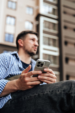 Young man sitting on a bench in a parkの写真素材