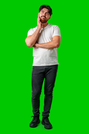 A man contemplates thoughtfully against a bright green backgroundの写真素材