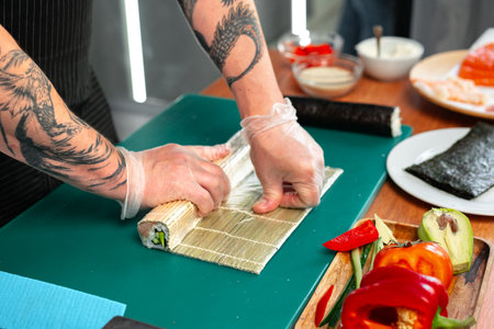 Preparing sushi rolls with fresh ingredients at a culinary studioの写真素材