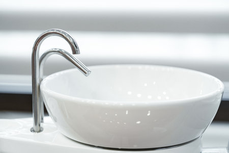 Modern dental workstation featuring an elegant bowl sink and sleek tap design in a well-lit clinicの写真素材