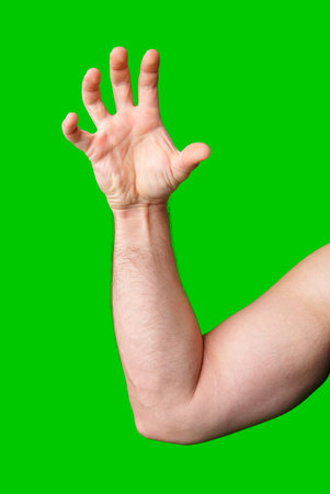 A close-up of a male arm with an outstretched hand against a bright green backgroundの写真素材
