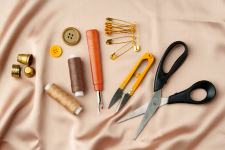 Sewing tools and materials arranged on soft fabric showcasing essential crafting supplies for creative projectsの写真素材