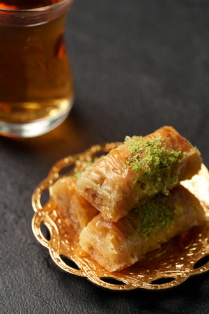 Enjoying delicious baklava and tea on a decorative plate in a cozy setting