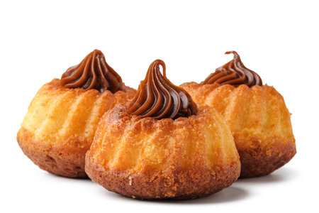 Delicious mini bundt cakes topped with chocolate frosting on a white backgroundの写真素材