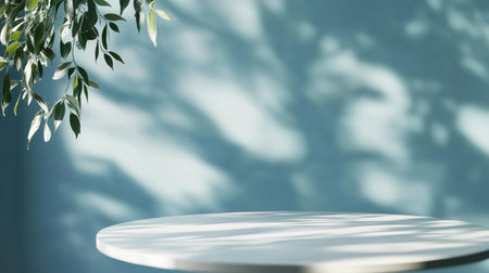 Circular table surrounded by gentle shadows on a soft blue wall in a tranquil setting during daylightの素材
