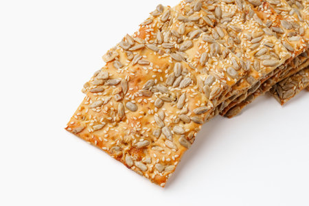 Sesame and sunflower seed crackers displayed on a white surfaceの写真素材