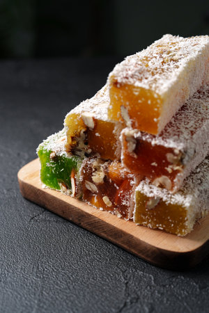 Colorful assortment of traditional Turkish delight stacked on a wooden boardの写真素材