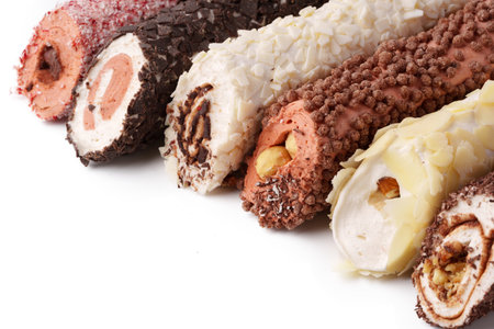Delicious dessert rolls filled with cream and coated in chocolate and nuts, ideal for any celebration or gatheringの写真素材
