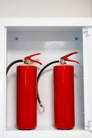 Fire safety equipment displayed in a storage cabinet for emergency preparednessの写真素材