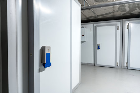 Secure storage facility with white units and blue access controls in a well-lit environment